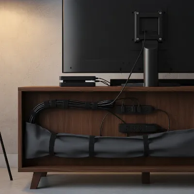 A modern living room with a TV stand, all cables neatly organized behind it with cable ties and sleeves, showcasing a clutter-free aesthetic.